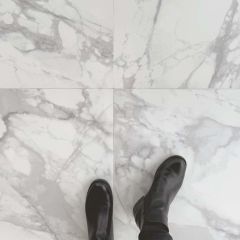 Calacatta Luxe Polished Porcelain Tiles - 595x595mm - four tiles pictured, close up with black boots