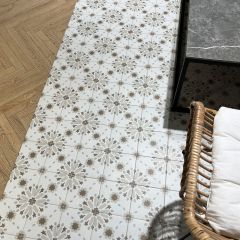 Image of Loire natural patterned tiles on a living room floor with wicker chair and marble coffee table., oak herringbone floor tiles bring contrast to the image