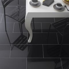Premium absolute black granite 610x305mm pictured brickbond style on a dining room floor, a contemporary white table, black metal chairs and two coffee cups on the table