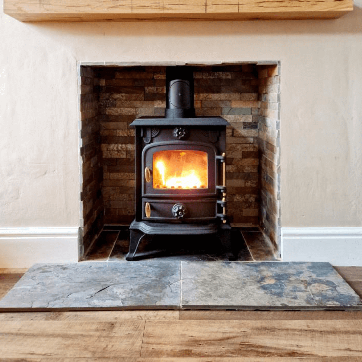 Natural Sheera multicolour slate tiles 600x400mm laid in a fireplace hearth with co-ordinating sheera multicolour split face mosaic tiles surrounding a log burner