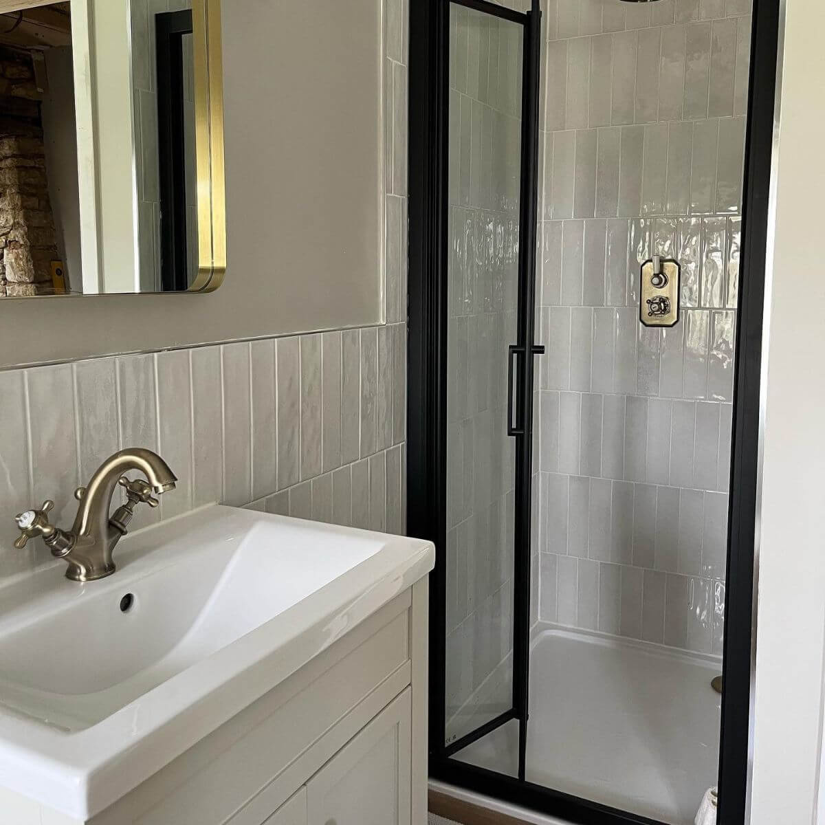 Paris Pearl Brick Wall Tiles laid in a vertical offset pattern featured in an enclosed shower area and half way up the walls around the room.